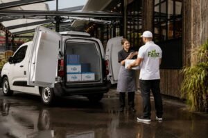 Faaz Foods delivery driver unloading wholesale food supplies outside a restaurant in Smethwick using a branded delivery van.