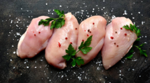 Fresh raw chicken breast fillets with parsley and pepper