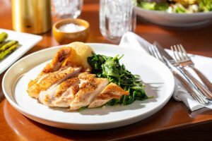 Grilled chicken breast served with spinach and roasted potatoes
