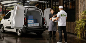 Faaz Foods delivery driver unloading wholesale food supplies outside a restaurant in Smethwick using a branded delivery van.