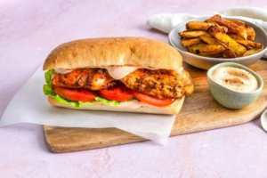 Grilled chicken fillet burger with lettuce, tomato, fries and dipping sauce